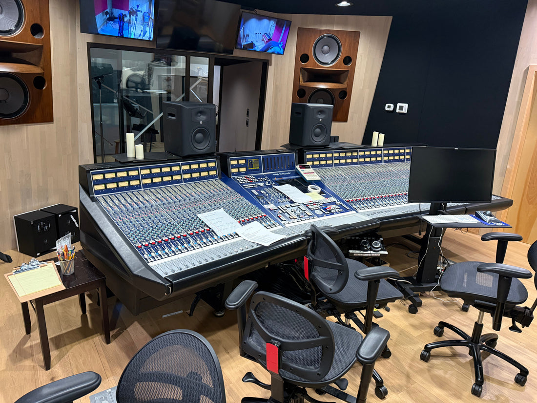Recording studio control room with a large mixing console and Stealth chairs